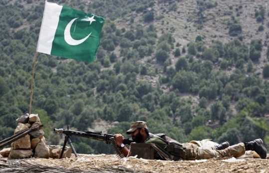 Pakistani-Flag-Photos-A-soldier-with-machine-gun-under-the-Pakistani-flag-Pakistan-Flag-Pics-and-Images